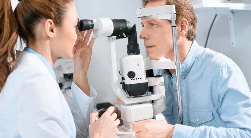 Man receiving an eye exam covered by vision insurance.