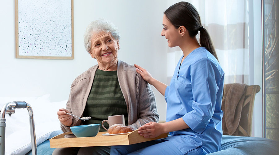 Young Female Nurse w Elderly Woman Shutterstock_1768875746